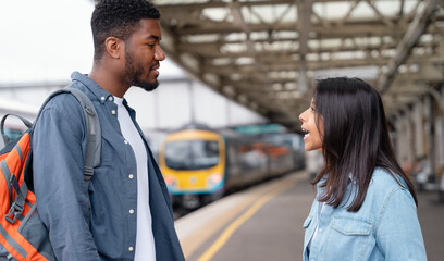 a young couple swearing and argueing with each othe at the train station on the platform The concept of disagreements in the family - obrazy, fototapety, plakaty