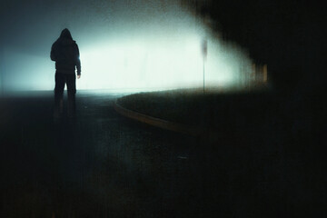 A mysterious hooded figure, back to camera, silhouetted against building lights on a foggy, spooky...