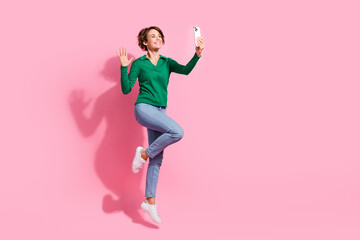 Fototapeta na wymiar Full length photo of positive young girl waving palm for selfie video call blogger recording fresh content isolated on pink color background