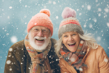 Portrait of a smiling senior couple wearing knitted hats and scarfs in snowfall. Winter season concept