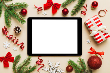 Digital tablet mock up with rustic Christmas decorations for app presentation top view with empty space for you design. Christmas online shopping concept. Tablet with copy space on colored background