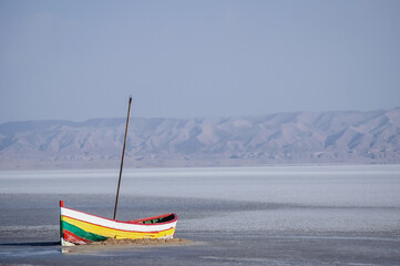 Old boat on dried Chott El Jerid endorheic salt lake in southern Tunisia