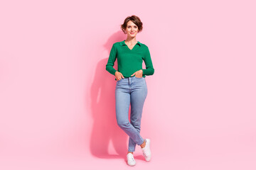 Full length photo attractive candid woman put hands pockets woman entrepreneur wear green top with jeans isolated on pink color background