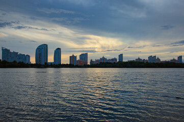 Scenic panoramic view of Obolon neighborhood with buildings near the Dnieper river in Kiev. Colorful vibrant sky