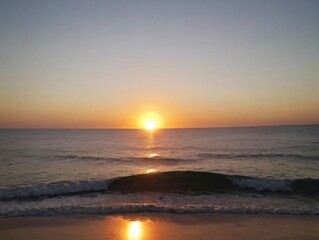 Fototapeta premium The Sun Sets Over The Ocean At The Beach