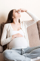 Sick pregnant woman blowing nose into tissue at home Healthy millennial healthcare concept