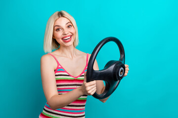Photo of young blonde lady wear knit trendy singlet hold leather steering wheel excited first time driving isolated on cyan color background
