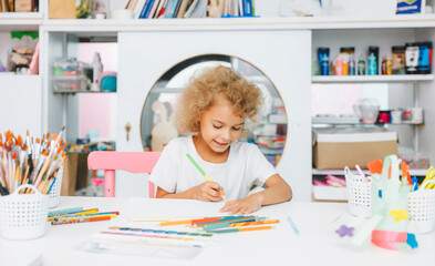 Fototapeta premium Cute little blonde preschooler girl draws at home