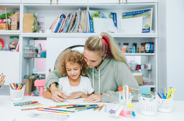 Fototapeta premium mother and child draw. daughter is engaged in creativity. mother and daughter paint.