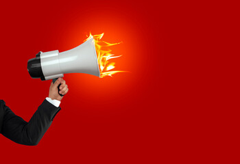 Loudhailer, hands holding burning megaphone. Announcement, advertising, public hearing concept....