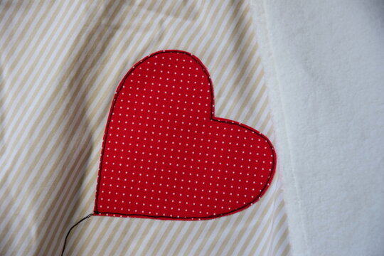 Detailansicht, Decke, beiger Baumwollstoff mit rotem Herz, Applikation