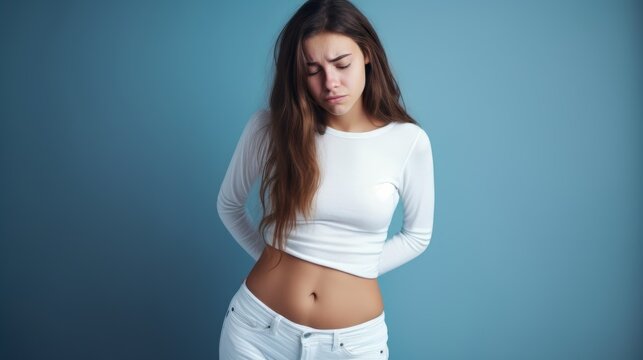 An teen girl with stomach pain infront of a clean one colored background.generative ai
