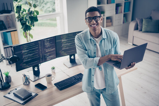 Photo of successful handsome young web designer content editor holding netbook distant worker doing python code at home indoors workspace