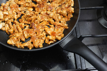 Making turkish doner kebab at home. Dirty kitchen stove. Marinated chicken in spices. Gyros dish recipe. Dinner frying background. Simple meat background. Closeup food texture.