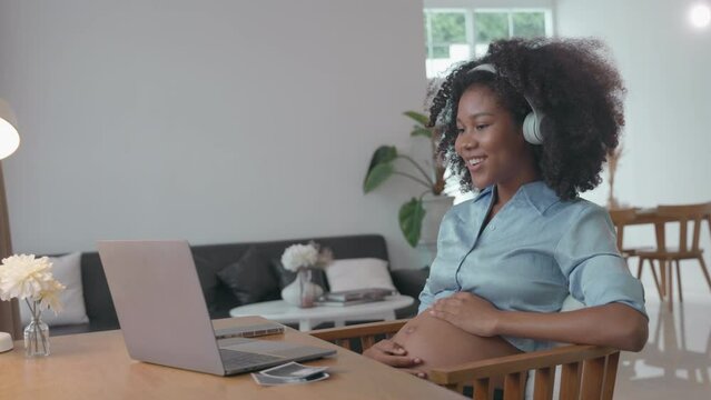 Pregnant African Woman Listening to Music with Headphones