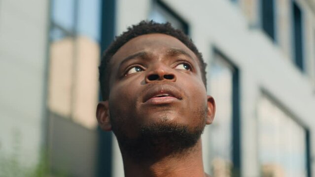 Close up pensive thinking ethnic man looking around outdoor business student guy look up on urban building think thoughtful African American male tourist contemplate outdoors outside lost in city