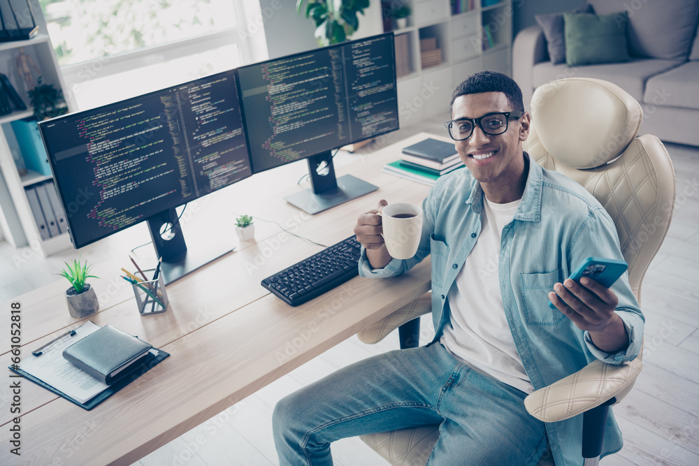 Aufkleber photo of positive young coder guy browsing phone holding mug with fresh coffee on online meeting sta