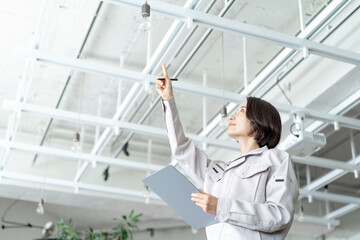 作業着を着てチェックする女性　