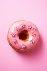 Strawberry donut with icing on pastel pink background. Sprinkled sweet and colourful glazed doughnut. Flat lay. Vertical food concept	