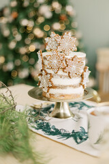 Beautiful birthday cake on the Christmas decorated kitchen with Christmas tree