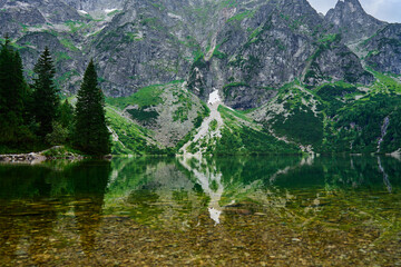 Amazing view on mountains range near beautiful lake at summer day. Tatra National Park in Poland. Panoramic view on Morskie Oko or Sea Eye lake in Five lakes valley