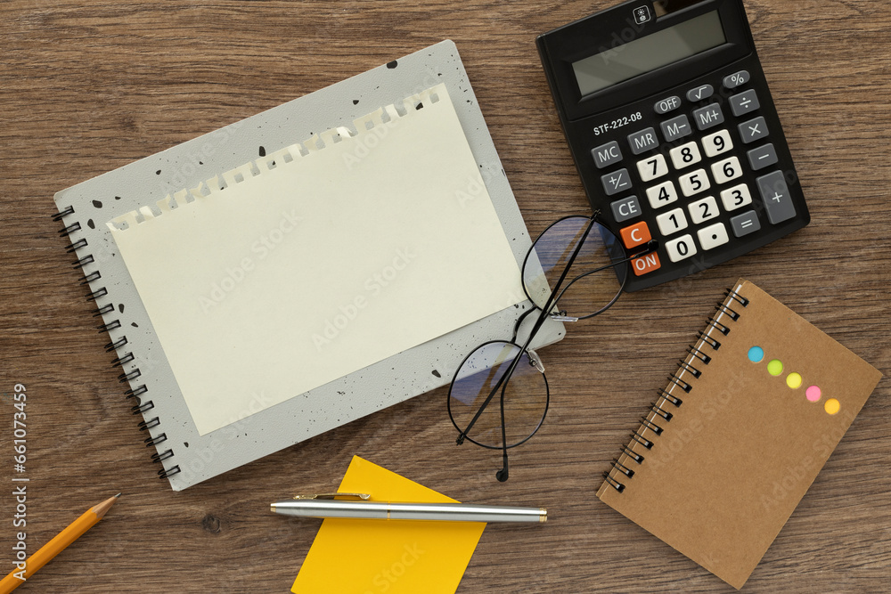 Poster blank notepad with glasses and calculator, top view. space for text on notepad page