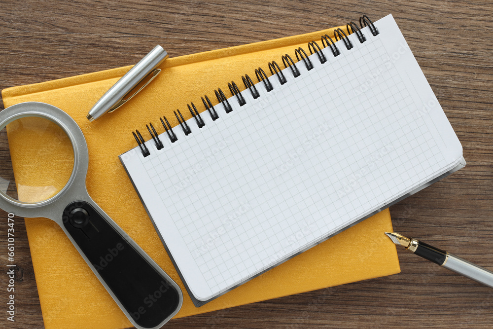 Poster office desk with yellow notepad and open notepad and accessories, on wooden background. top view wit