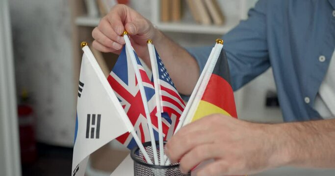 Language teacher man choosing between different countries flags