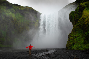 Feeling the power of nature in front of Skogafoss waterfall