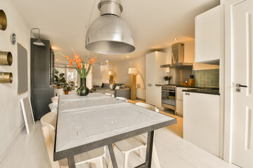 a kitchen, dining area and living room in a modern apartment with white walls and wood flooring on...