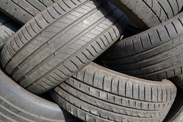 A heap of old car tyres. used rubber tires in a pile at repair garage 