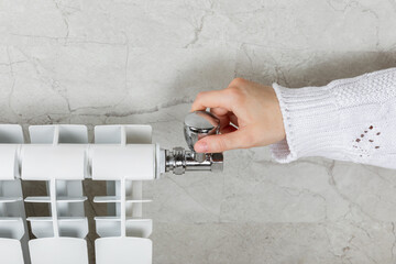 Central heating system.Increasing heating costs during the crisis.A woman regulates the temperature...