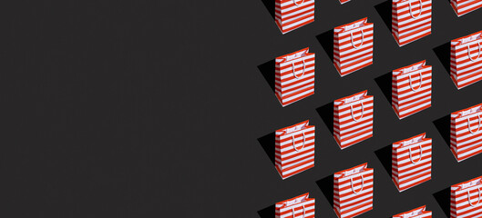 Pattern made from paper shopping bag on black background. Black friday sale, shopping concept. Banner with copy space.