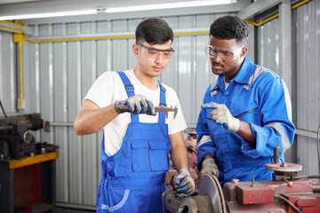 workers or technicians using calipers measures and checking lathe machine in the factory