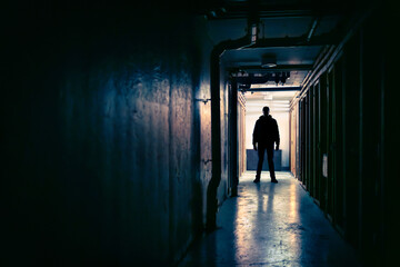 Killer, creepy, scary stalker man in dark corridor. Horror, thriller movie concept. Suspicious silhouette and figure in shadow. Maniac psycho criminal. Spooky mystery stranger at night. - obrazy, fototapety, plakaty