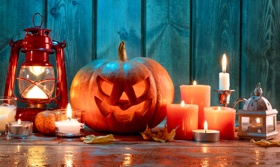 jack-o-lantern candles, lantern and leaves in dramatic lighting, halloween design concept.