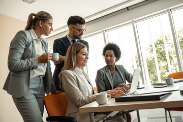 In a cozy, casual office, a group of business professionals monitors stock market activity with keen focus and expertise.	
