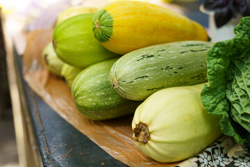 Green and yellow zucchini on the counter of a street mini market.
