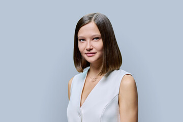 Fototapeta premium Portrait of young elegant business woman, on gray studio background
