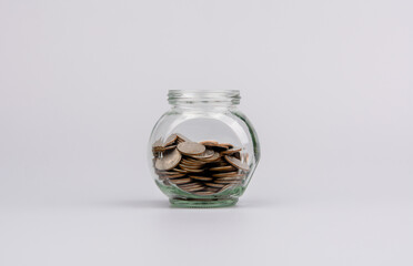 Saving coins in a glass jar Banking Finance Concepts of saving money, income, wages, cash flow, investments, mutual funds, financial taxes. financial loans