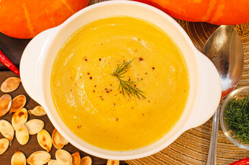 Pumpkin hot puree soup on a wooden table