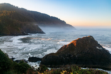 Sun peaking through at dawn on the magnificent Oregon Coast near Heceta Lighthouse.