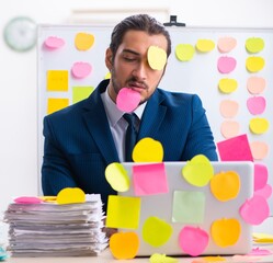 Young male employee in conflicting priorities concept