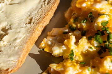 Scrambled eggs with chives and light bread with butter. - obrazy, fototapety, plakaty