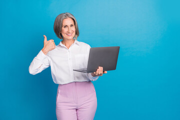 Photo of shiny confident lady wear white shirt typing email modern gadget thumb up empty space isolated blue color background