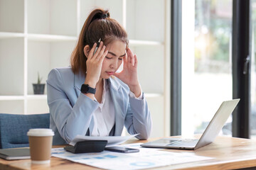 Confused Asian woman thinking hard about how to solve problems online looking at laptop screen. Serious Asian businesswoman worried focused on solving difficult computer at office