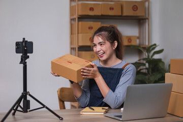 Asian blogger review products and video camera on her phone, sell them online, and showcase her products online on social media. ecommerce business live streaming vlog new normal concept