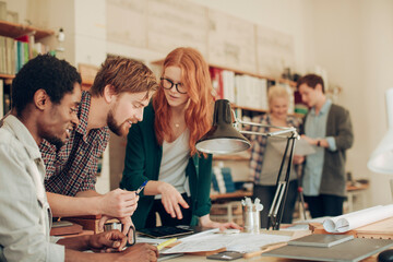 Young and diverse group of architects working on a project together in a startup company office