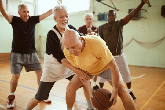 Senior men playing basketball in a indoor gym