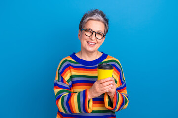 Photo of peaceful cheerful person toothy smile hands hold fresh coffee cup isolated on blue color background